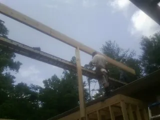 Carpenter setting a ridge beam over a new addition frame — Ice Dam Removal by Roofing Brothers in Moodus