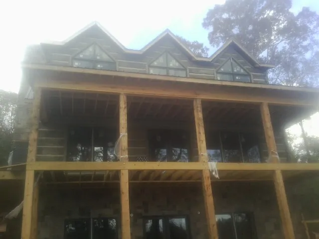 Dormers and porch framing on a large log home under construction — Roof Coating work by our crew in Moodus