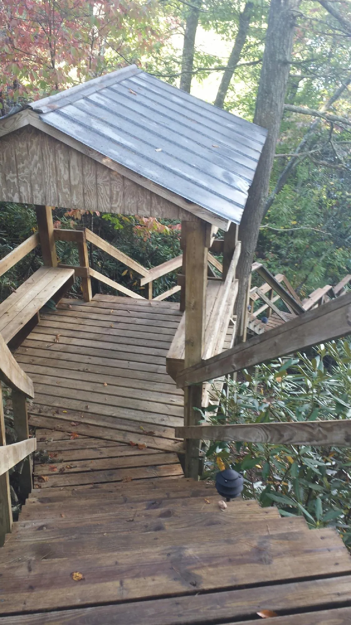 Metal roofed shelter over wooden steps on a wooded walkway — Skylight Repair & Installation work by our crew in Moodus