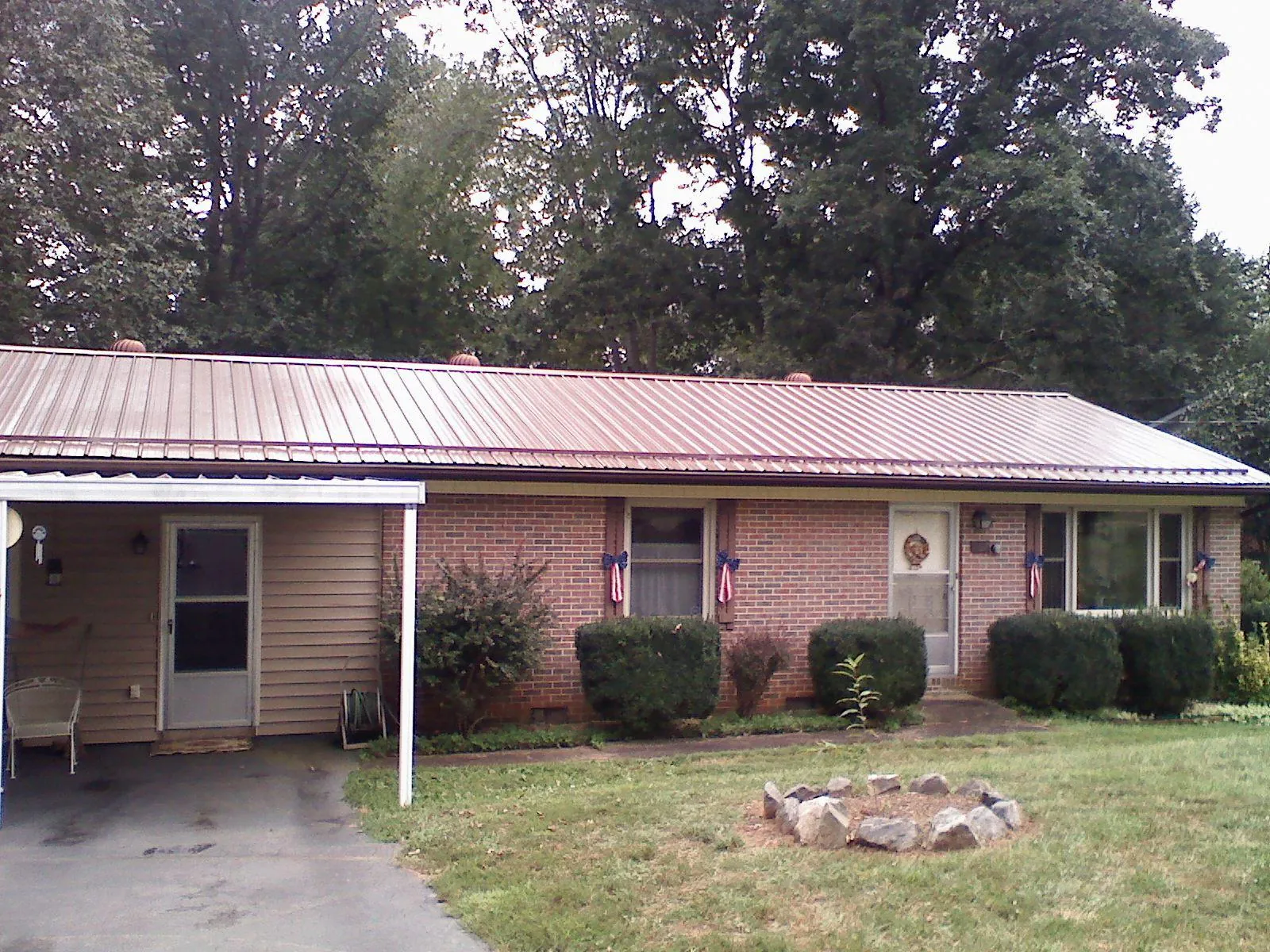 Bronze metal roof and carport on a brick ranch home — Roof Repair work by our crew in Moodus